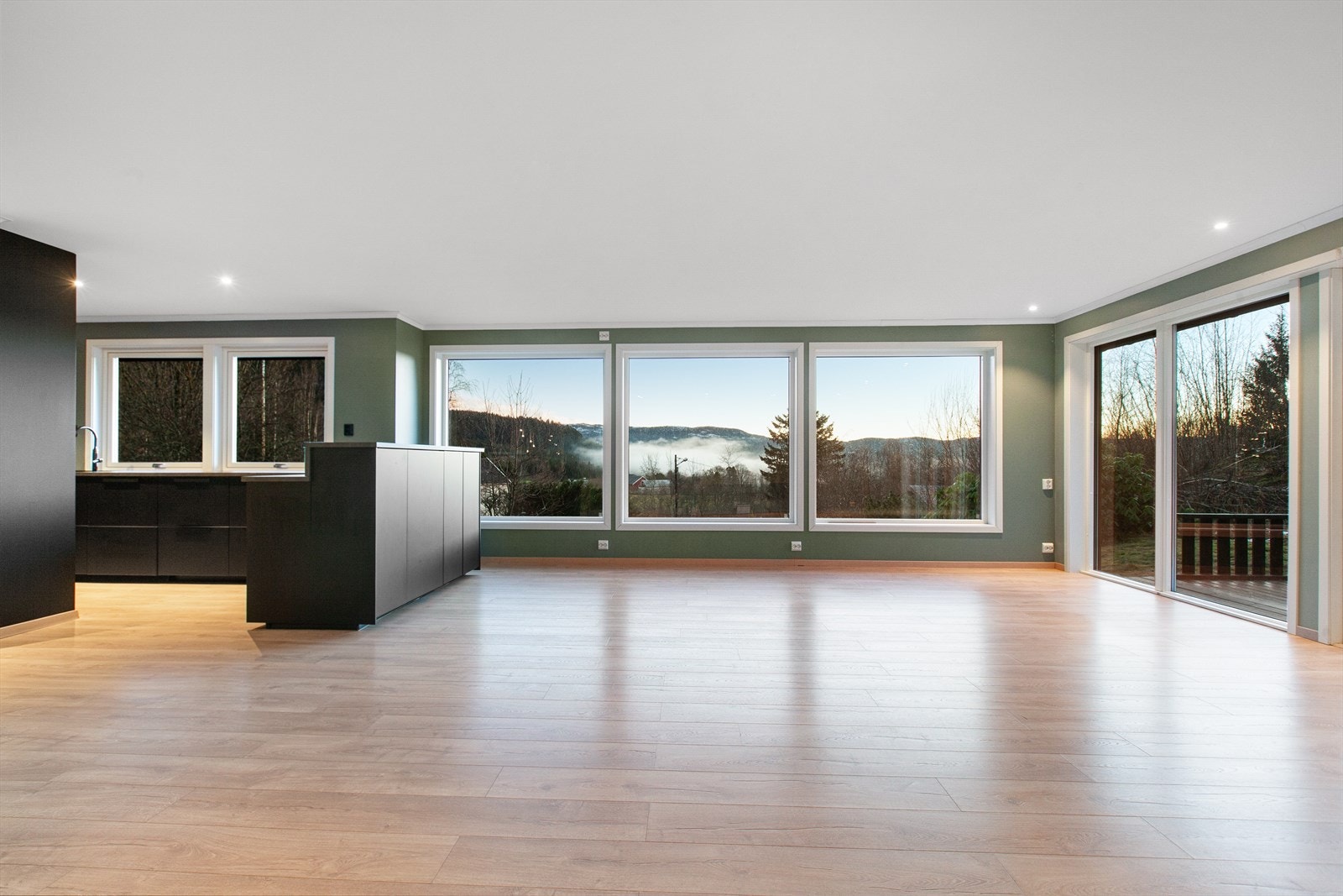 Stue-/kjøkkenarealet strekker seg over hele 55 kvm. og oppleves som svært lys og luftig takket være de store vindusflatene Galleribilde