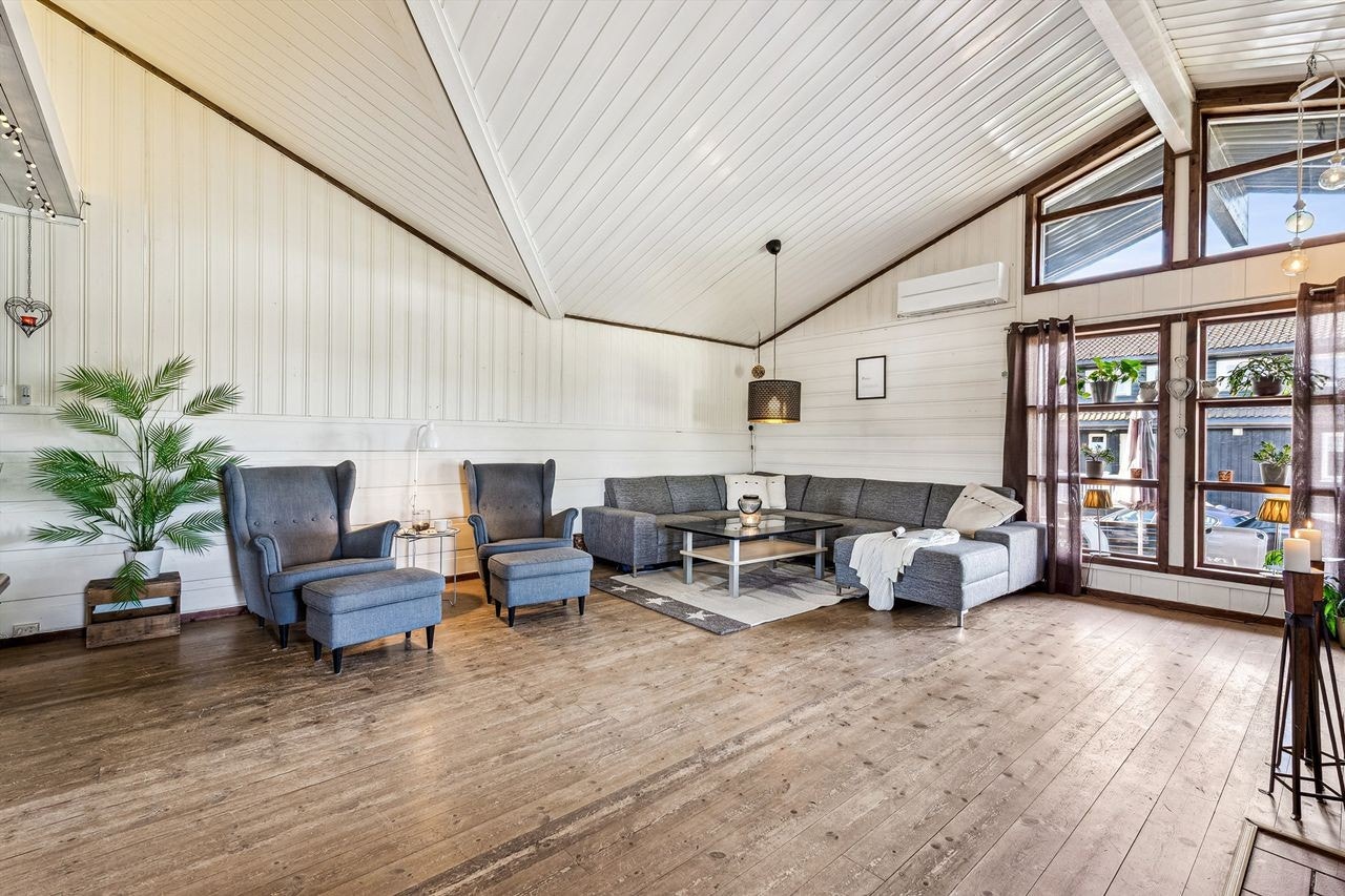 Stue med imponerende takhøyde og skråhimling gir en luftig og åpen atmosfære. Galleribilde