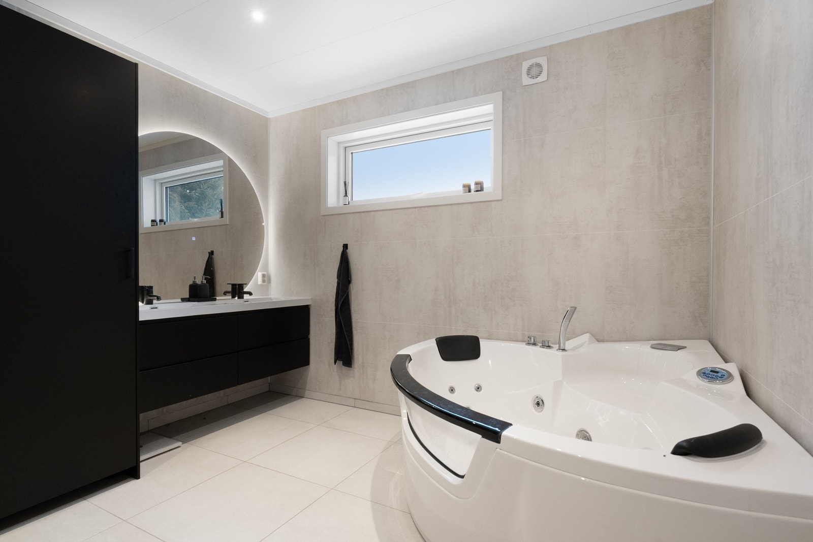 Her er det både hjørnebadekar med massasjefunksjon og en bred servantinnredning. Galleribilde