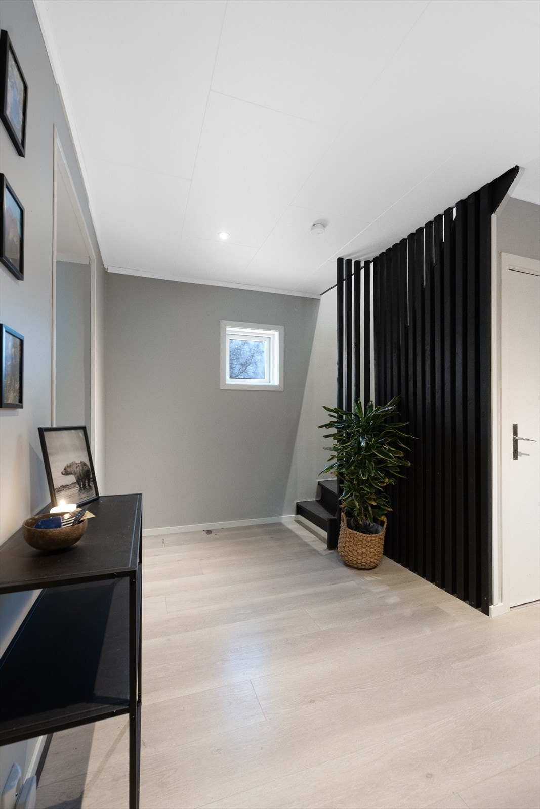 Hallen har en moderne spilevegg som skaper et stilrent skille mot trappen. Galleribilde