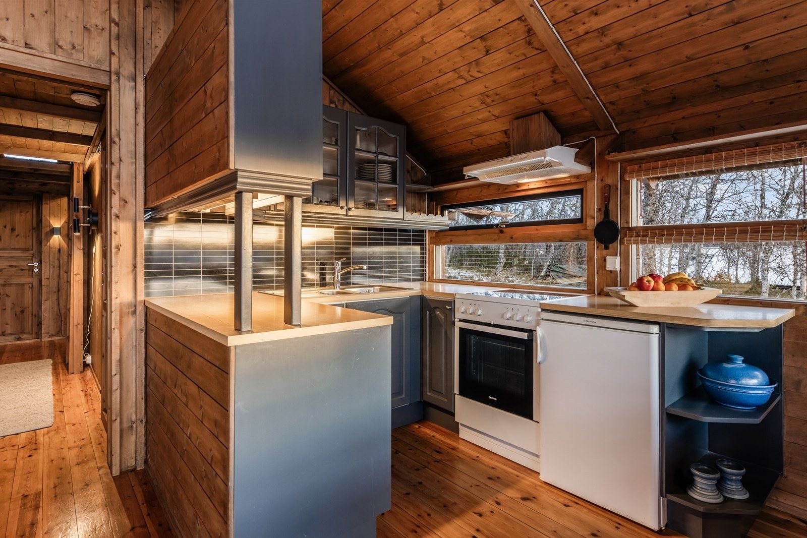 Laminat benkeplate med nedfelt oppvaskkum, frittstående komfyr og kjøleskap. Galleribilde