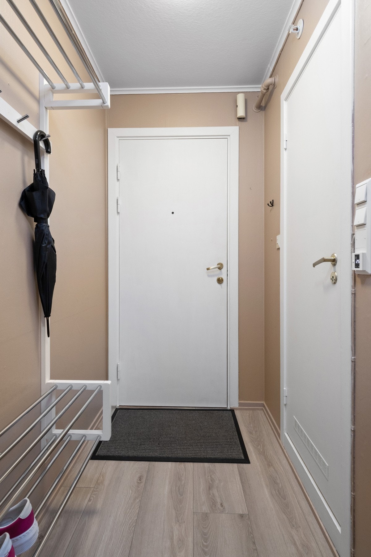 Praktisk entrè med oppheng til klær og sko Galleribilde