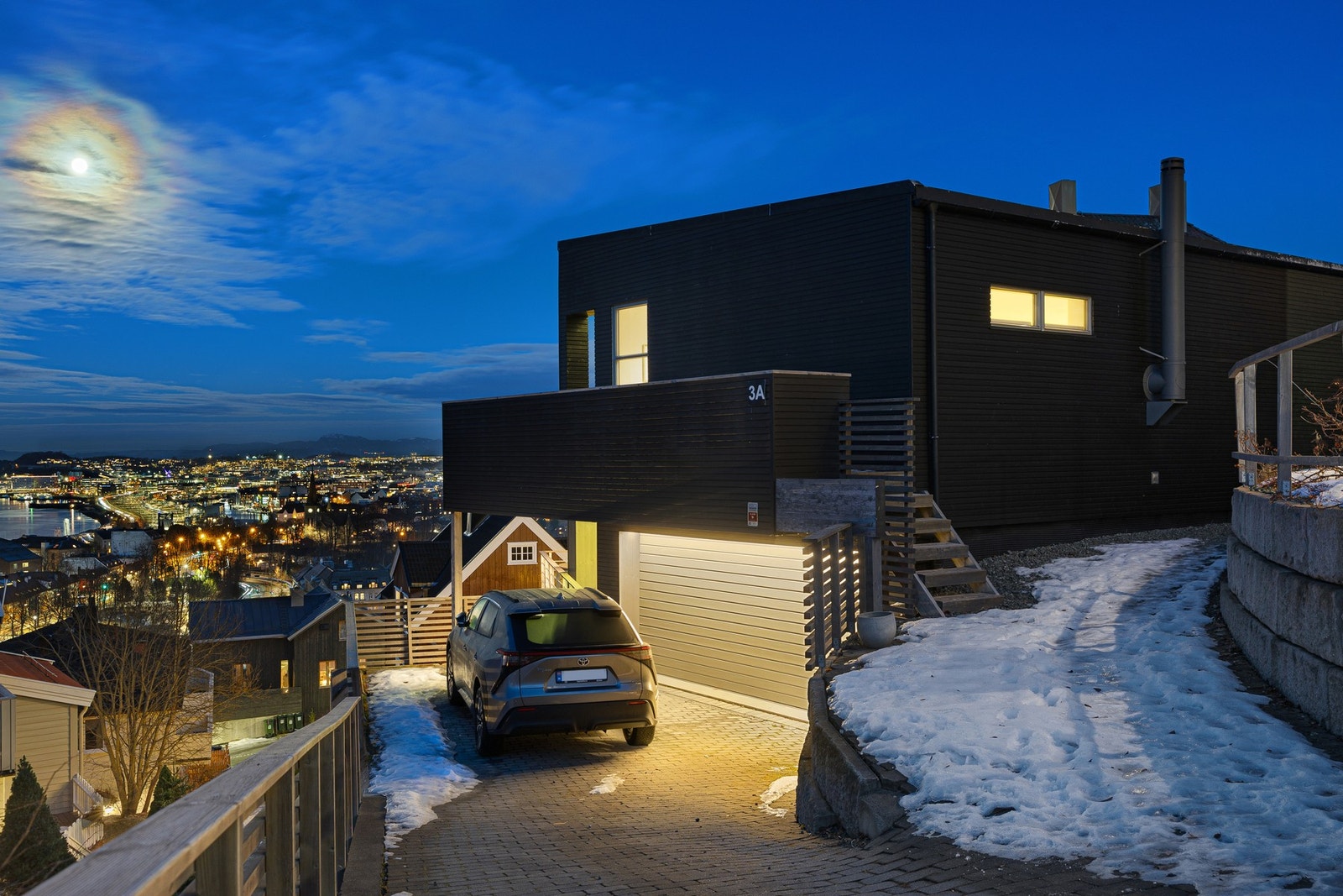 Steinbelagt innkjørsel med varmekabler for effektiv snø- og issmelting og parkering i en romslig garasje. Galleribilde