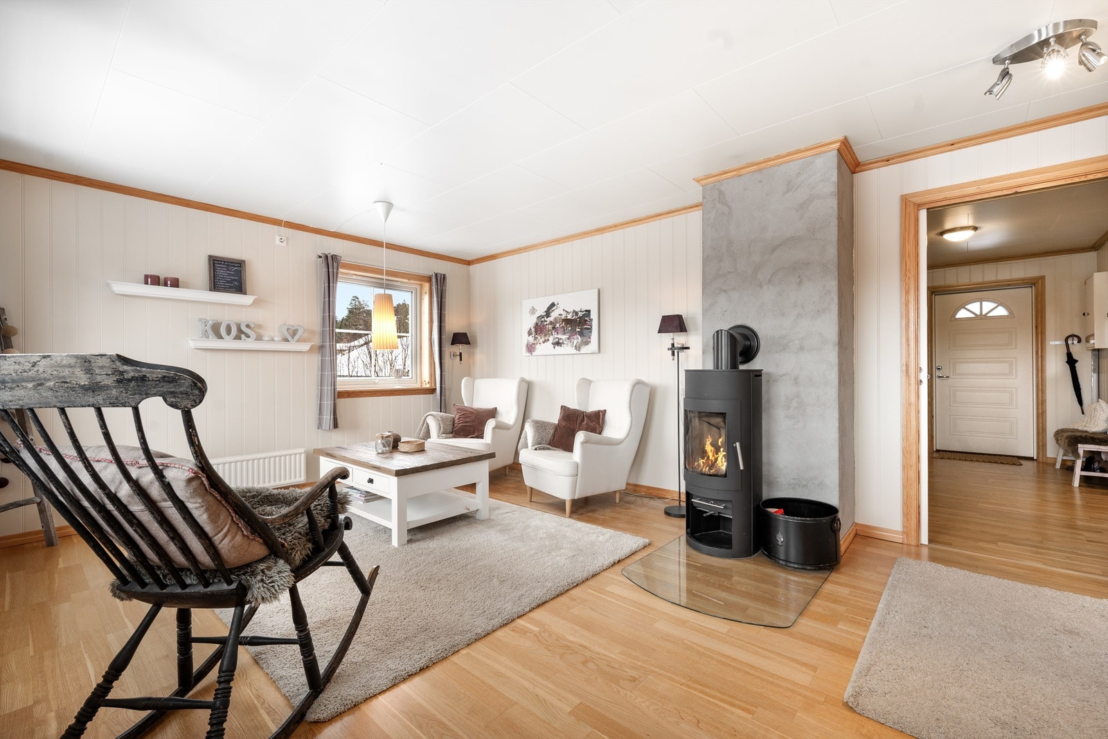 Stue med koselig peisovn. Inngangspartiet til høyre. Galleribilde