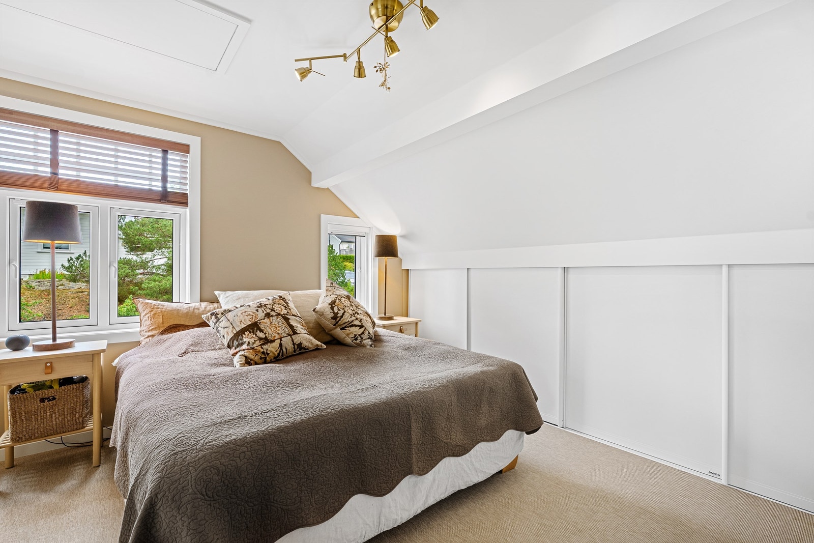 God lagringsplass i skyvedørsgarderobe og ellers et romslig soverom med vegg til vegg teppe Galleribilde