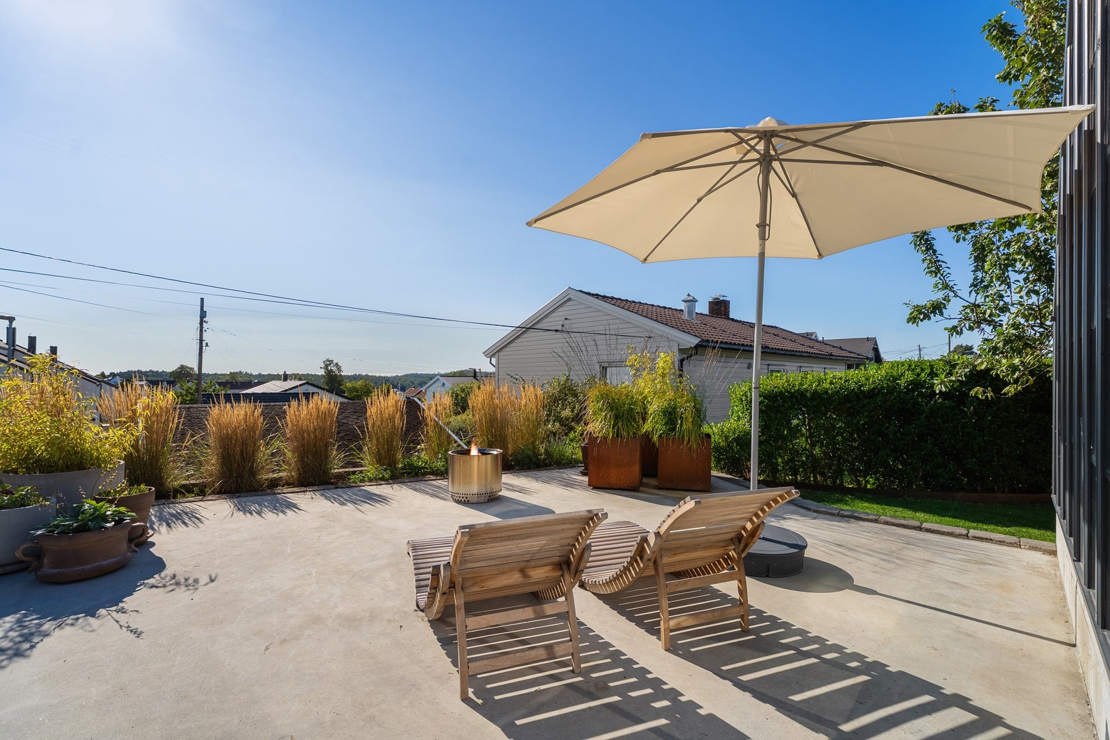 Flott platting på fremsiden av drivhuset med pusset betong. Her får du fin kveldssola! Galleribilde