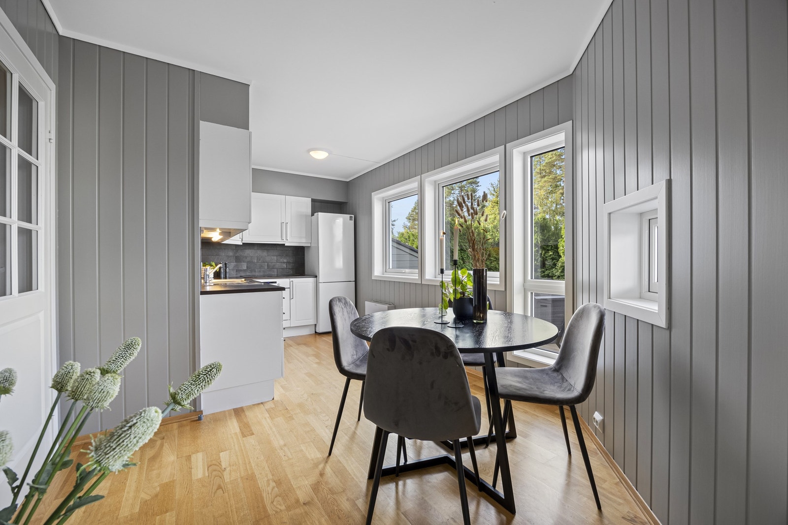 Åpen løsning til kjøkken fra stuen med plass til et lite spisestuebord i mellom. Galleribilde