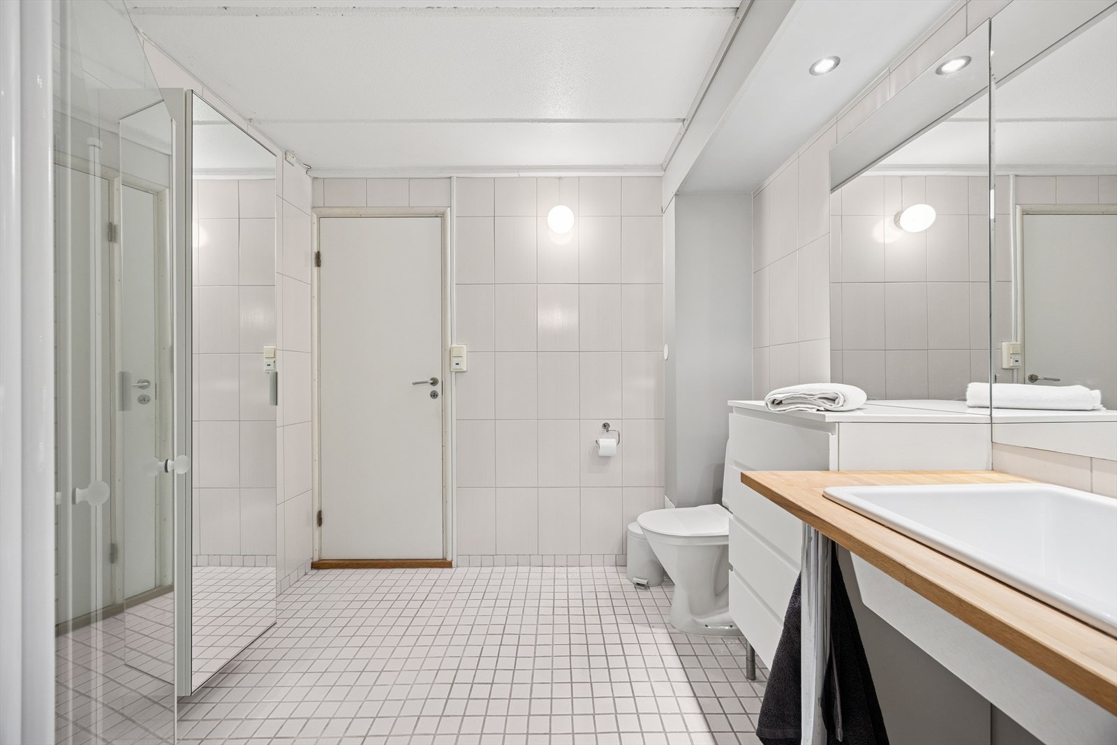 Badet er innredet med klosett, servant nedfelt i en heltre benkeplate og et dusjhjørne med dører. Det er opplegg for vaskemaskin og mekanisk avtrekk. Galleribilde