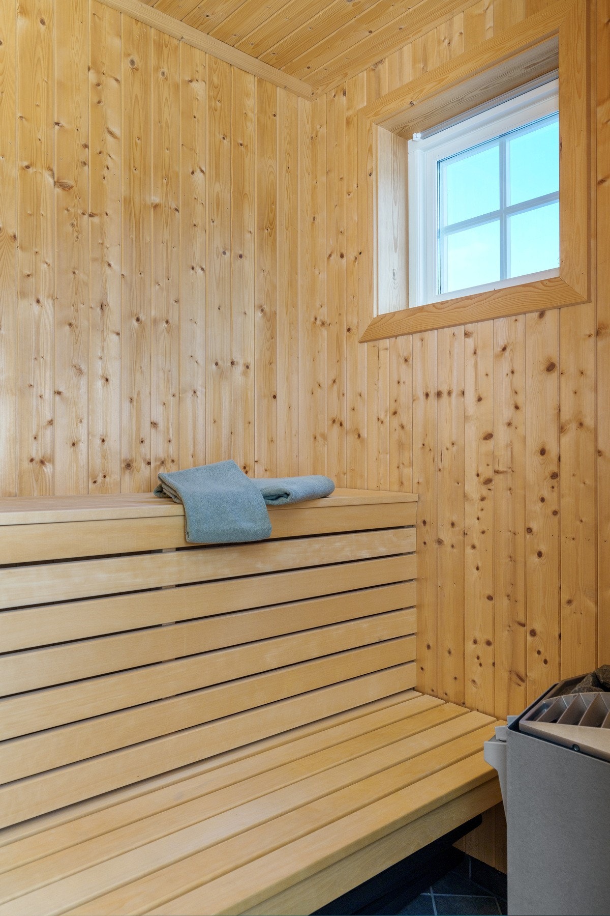 I badstuen er det flis på gulv, granpanel på vegger og himling. Her er det innsatt badstuovn og badstubenk i bøk. Galleribilde