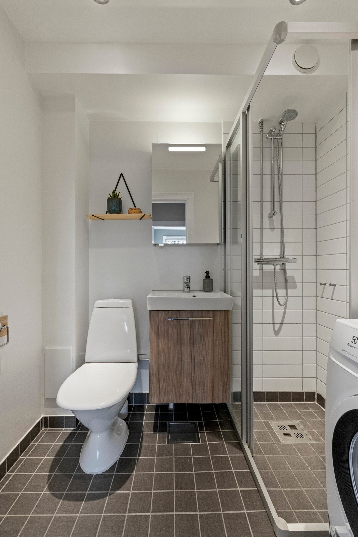 Badet ble oppusset i regi av borettslaget og har gulvstående toalett og dusjdødrer i herdet glass Galleribilde