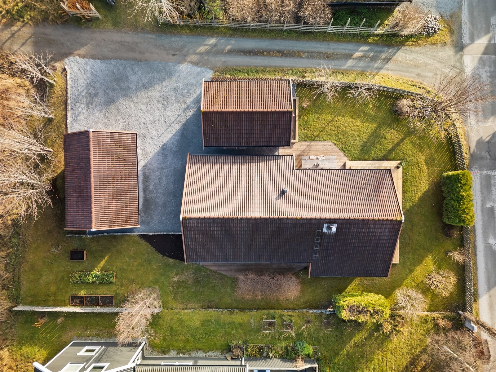 Tomten er på 694 kvadratmeter og har store terrasseflater, flat plen og en stor, gruslagt oppkjørsel. Galleribilde