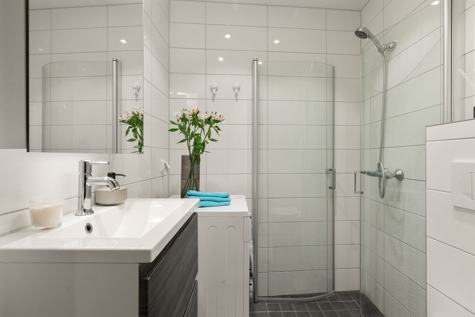 Badet er utstyrt med vegghengt toalett og dusjhjørne med innfellbare glassvegger. Galleribilde