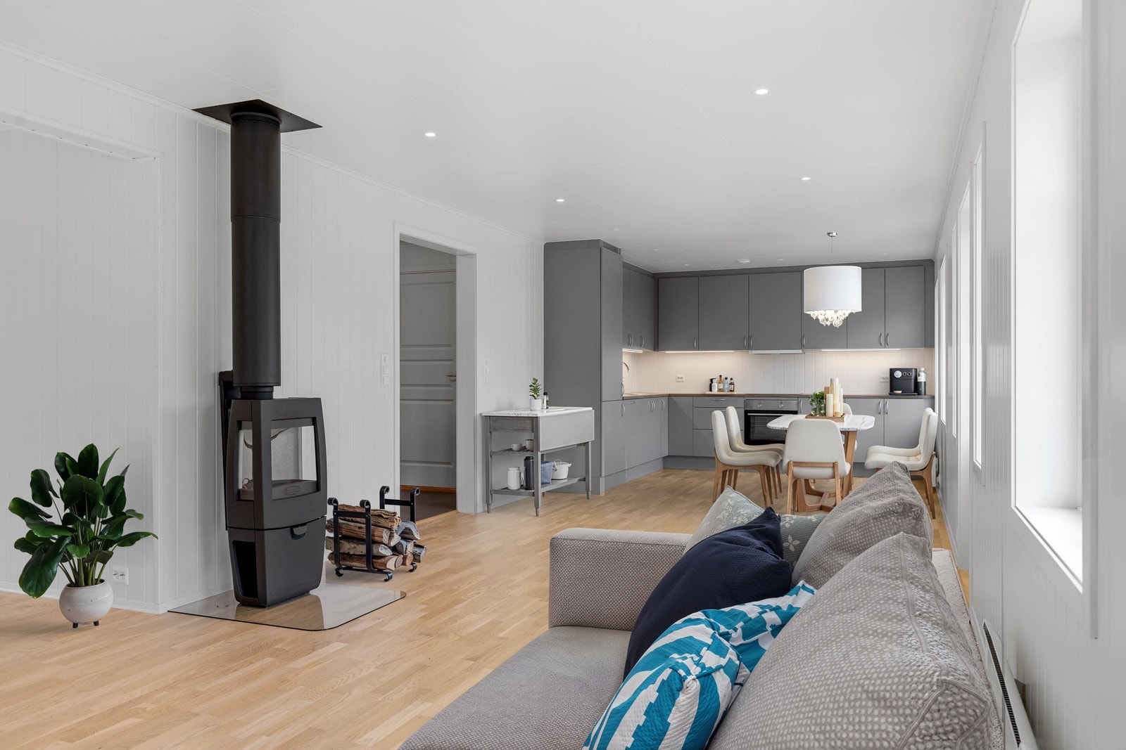 Kjøkken/stue har store vindusflater, peisovn, parkett på gulv og mye mer. Galleribilde