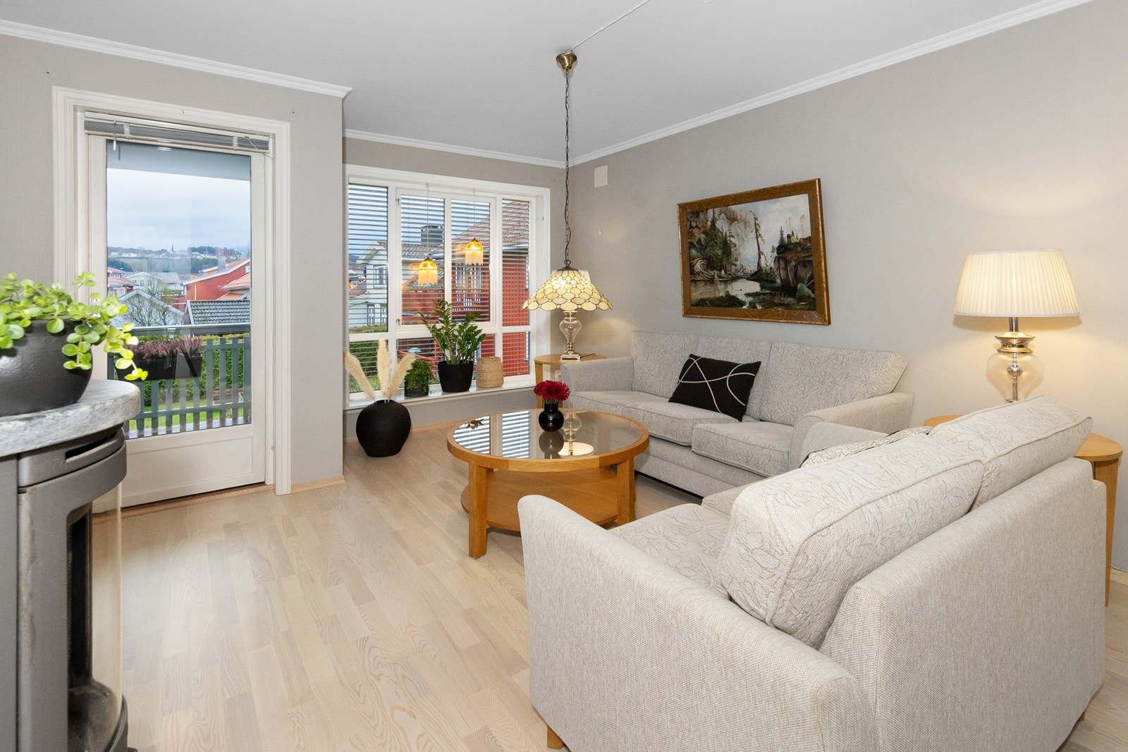 Romslig stue med vinduer ut mot sameiets fellesareal. Dør ut til terrassen til venstre. Vedovn i kleberstein som gir god og lun varme. Galleribilde