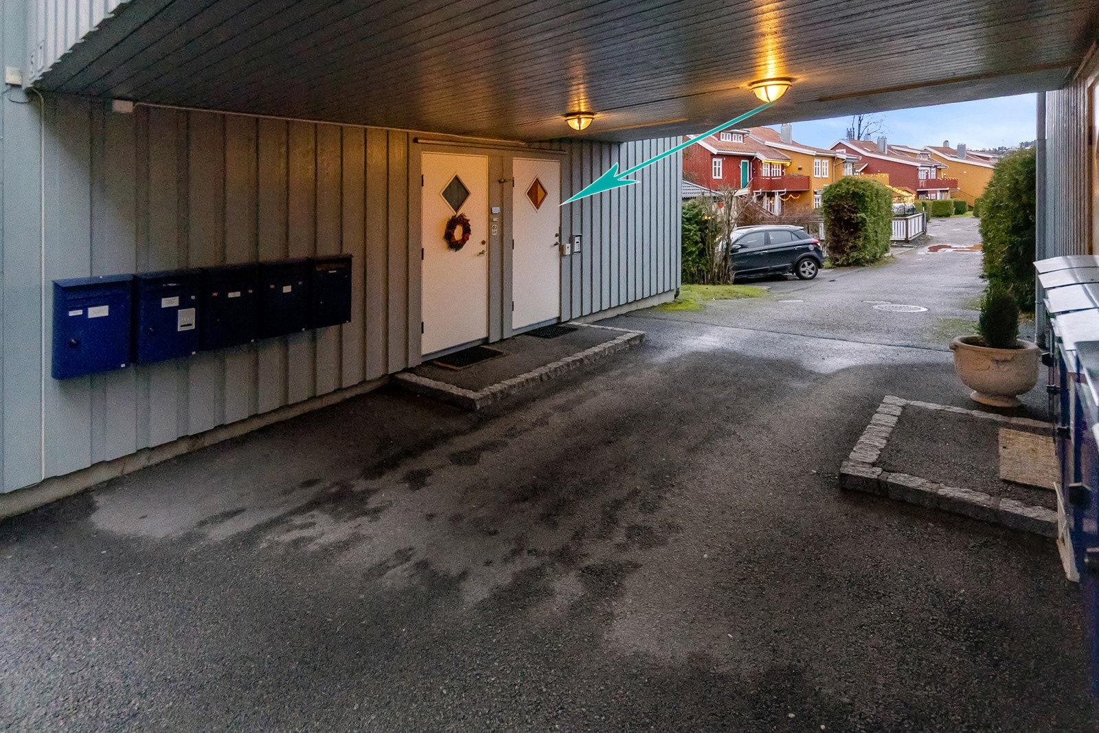 Inngangen til leiligheten er markert med pil. Her er det calling system så man låser opp fra leiligheten. Praktisk med overbygg hvis du skal hentes med bil. Garasjen er rett over vegen. Galleribilde