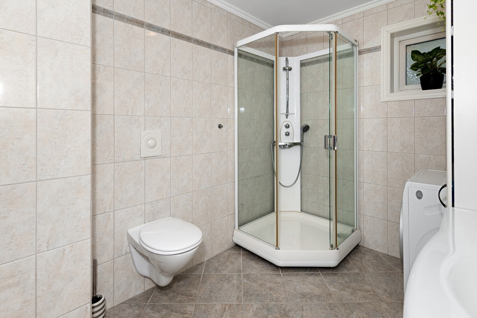 Dusjabinett og vegghengt toalett som gir for lettere renhold. Galleribilde