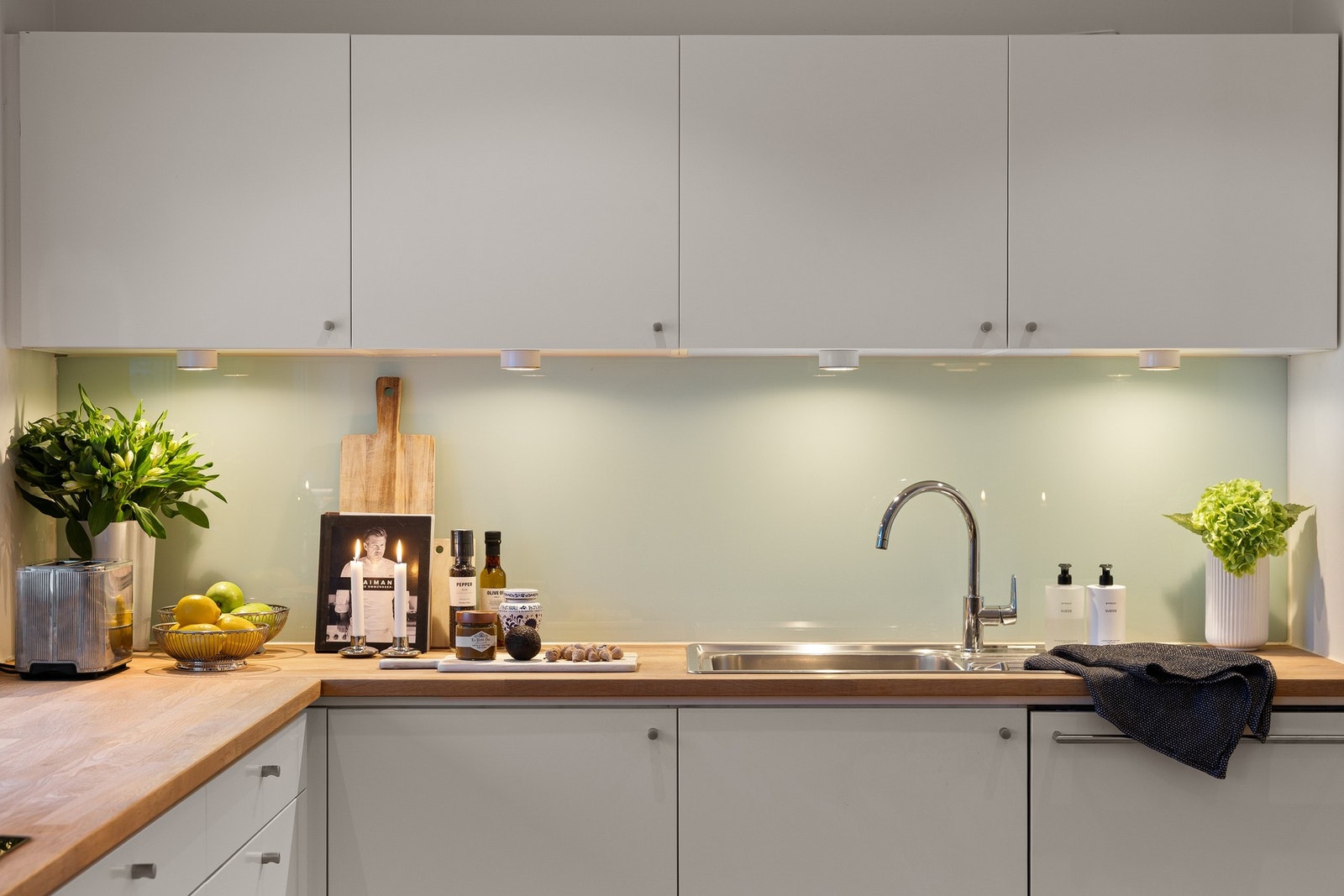 Integrerte hvitevarer består av stekeovn, induksjonstopp (80 cm), oppvaskmaskin og kjøl-/fryseskap. Fin belysning med spotter under overskapene. Galleribilde