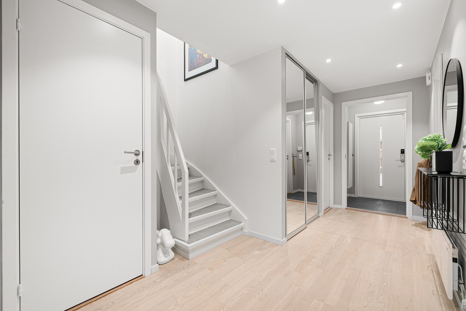 Nede i 1. etasje er det en innbydende hall med tilgang på tre soverom, bad, toalettrom og vaskerom. Oppbevaring i praktisk bod under trapp. Galleribilde