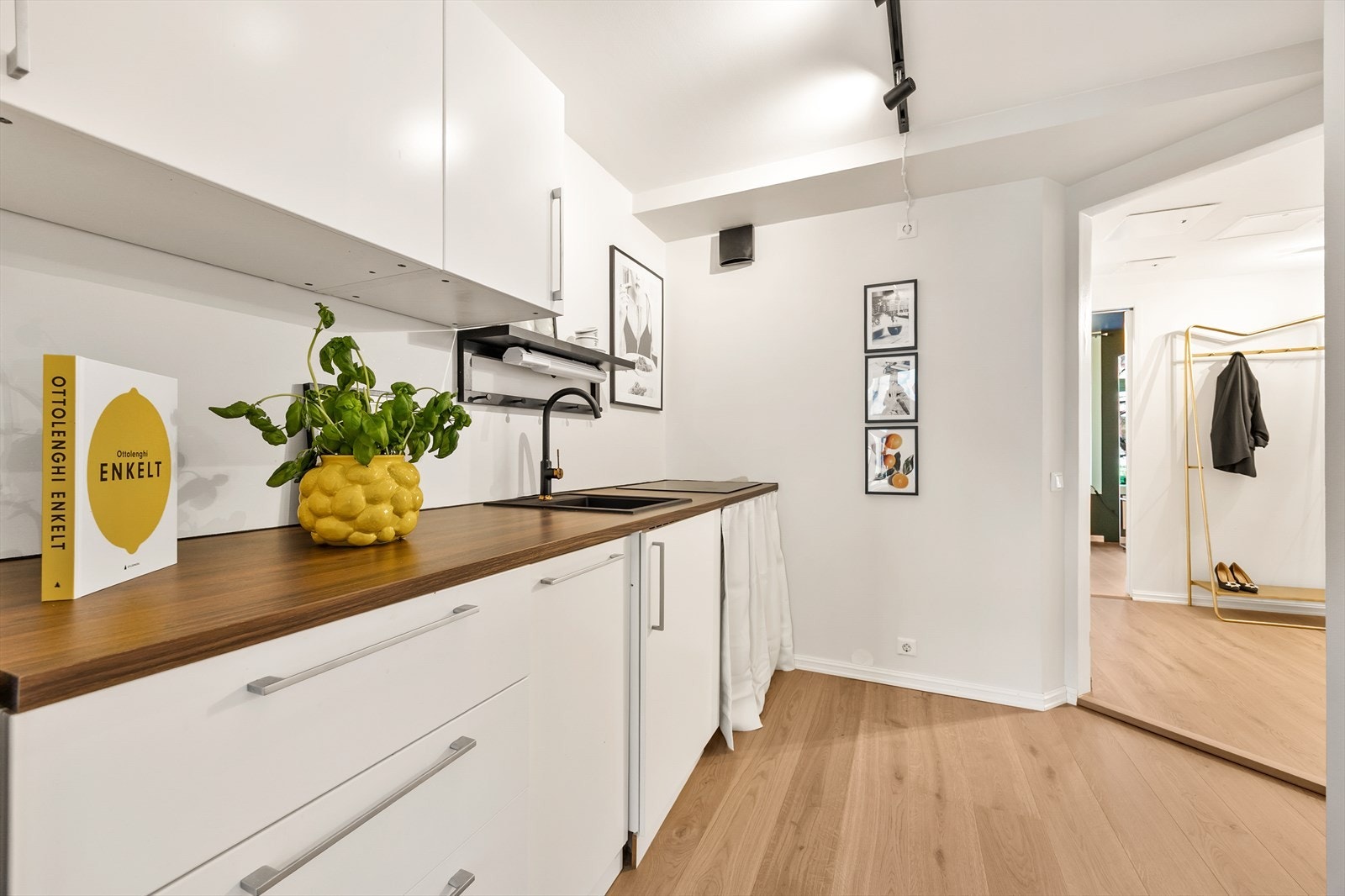 Kjøkkenet har en hvit, slett laminatinnredning med god skapplass. Galleribilde