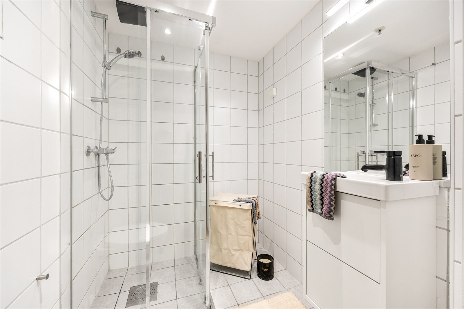 Badet har et praktisk dusjhjørne med innsvingbare glassdører og opplegg for vaskemaskin. Galleribilde