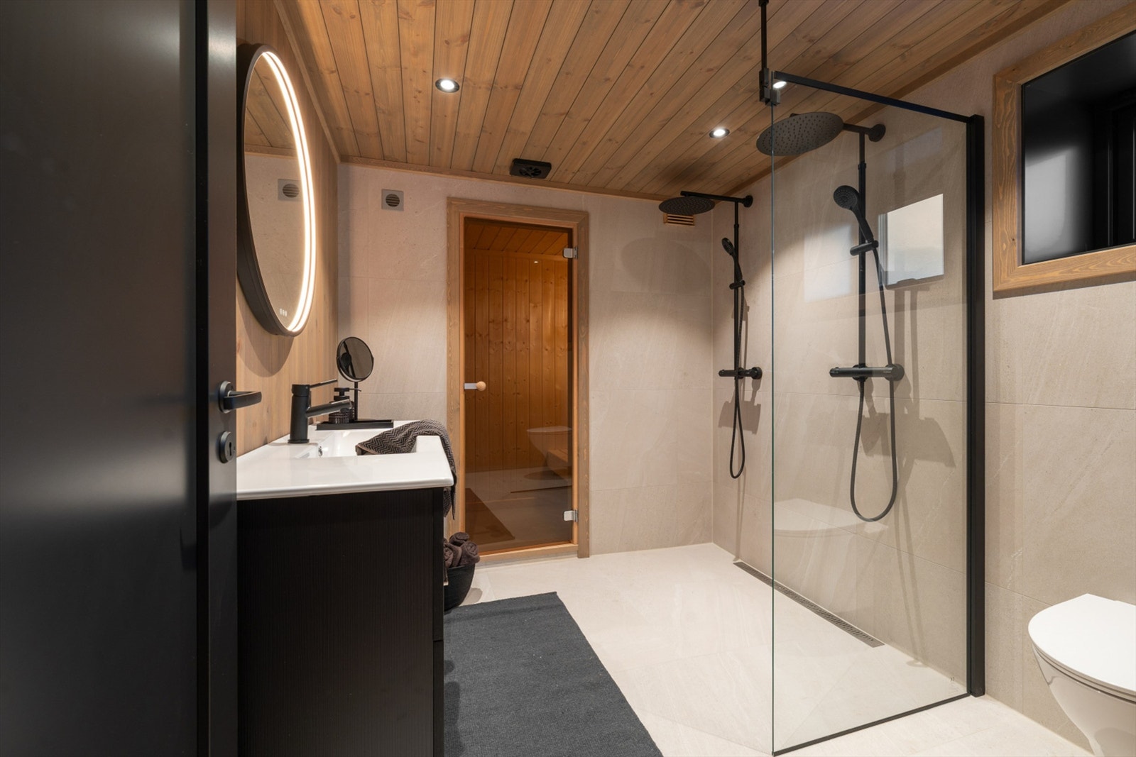 Badet i 1. etg. med dobbelt dusj og inngang til badstue, Vegghengt wc, og servant med skuffer under. Galleribilde