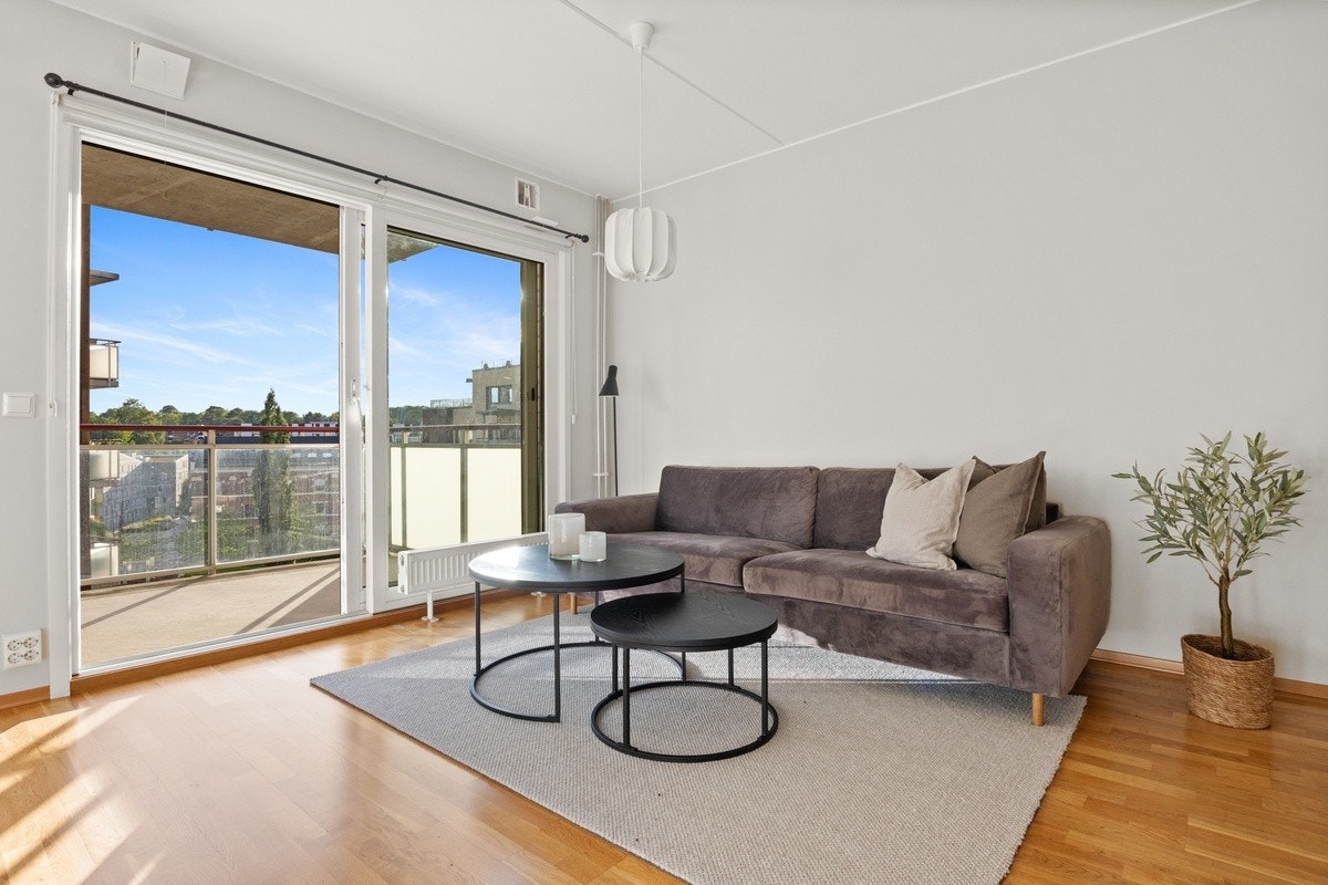 Store vinduer og utgang til balkong gjør at leiligheten føles åpen og romslig. Galleribilde