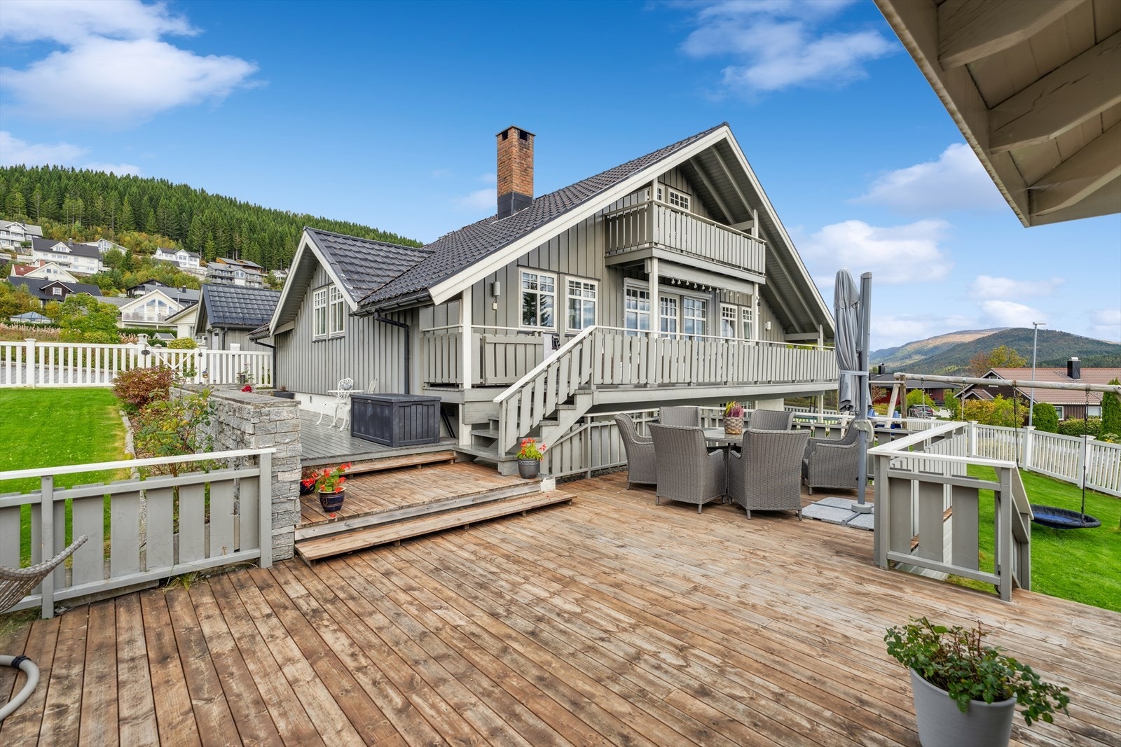 Fra terrassen leder en trapp ned til en utvidet uteplass med overbygg, som gir deg muligheten til å nyte utelivet uansett vær. Galleribilde