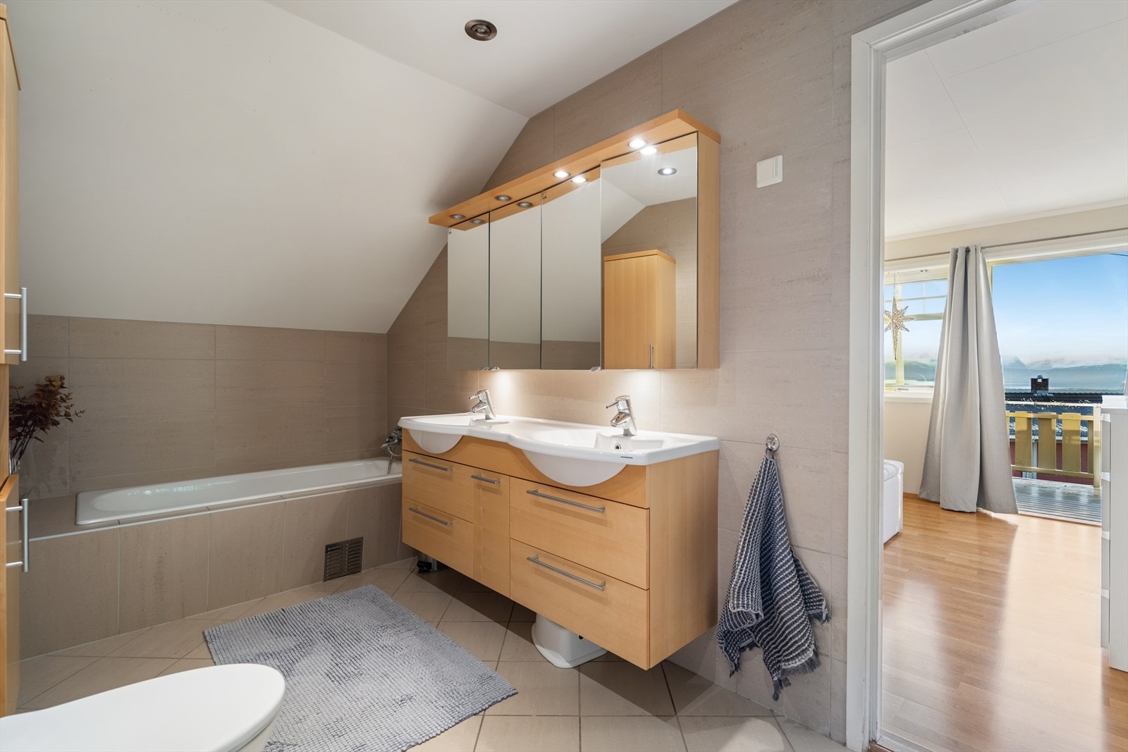 Innbydende helfliset bad. Rommet har baderomsinnredning, badekar, dusj og wc. Direkte tilkomst til hovedsoverommet. Et godt sted å starte dagen! Galleribilde