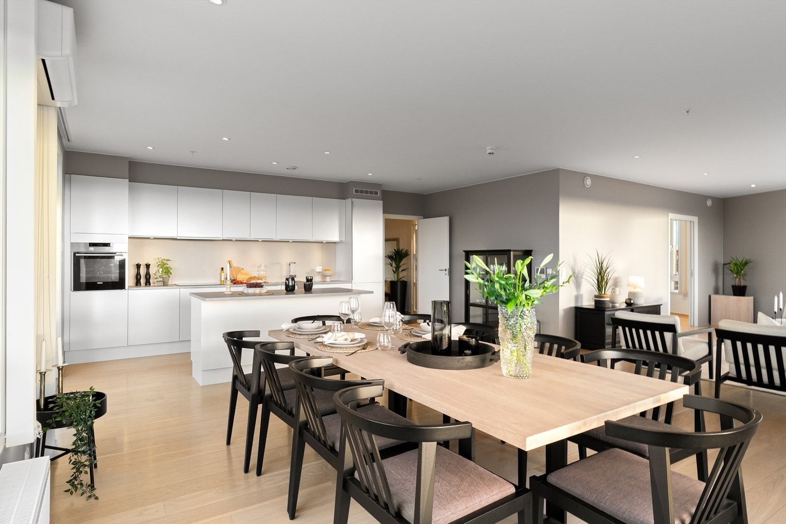 Moderne hvitt slett kjøkkeninnredning fra HTH med kjøkkenøy og integrerte hvitevarer Galleribilde