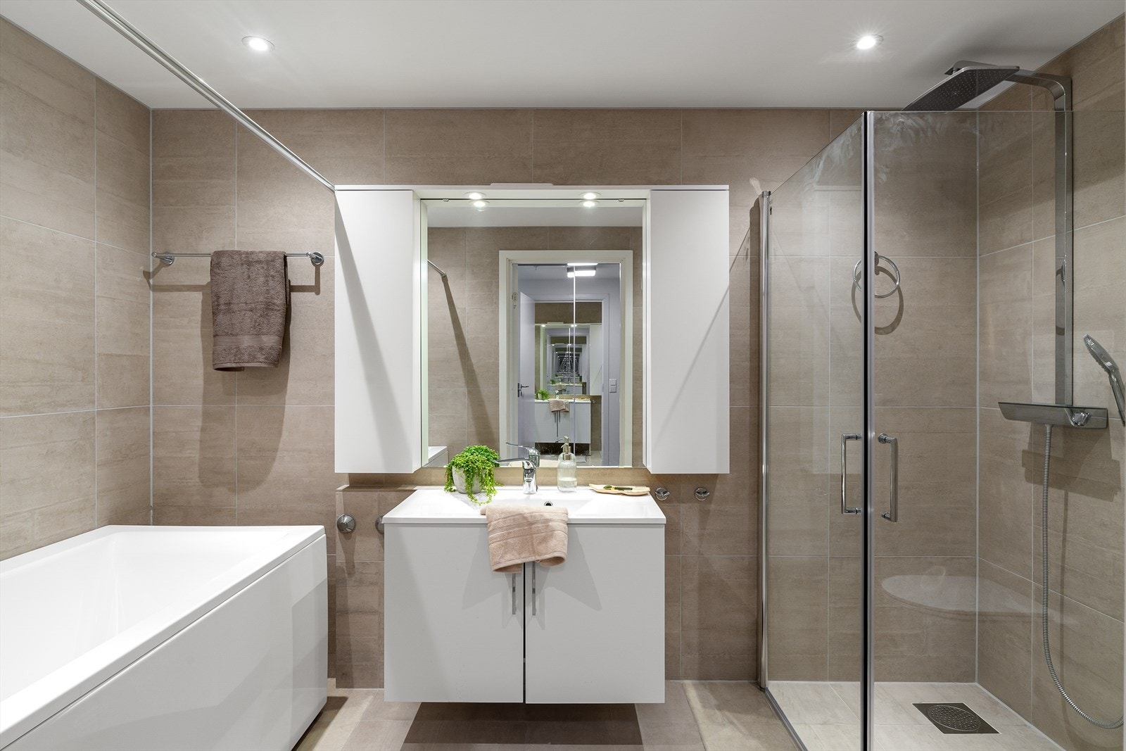 Lekkert helfliset bad med gulvvarme, dusjnisje, badekar, vegghengt wc og vask i møbel. Galleribilde