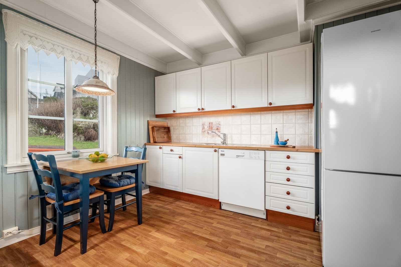 Det holder et klassisk preg med lyse fronter og frittstående hvitevarer. Galleribilde