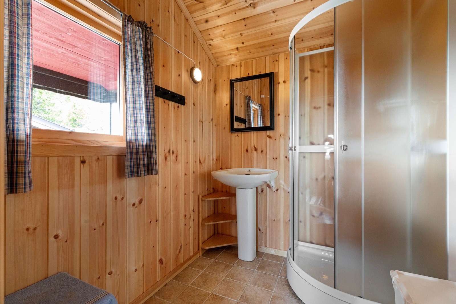 Bad med flislagt gulv og panel på vegger Galleribilde