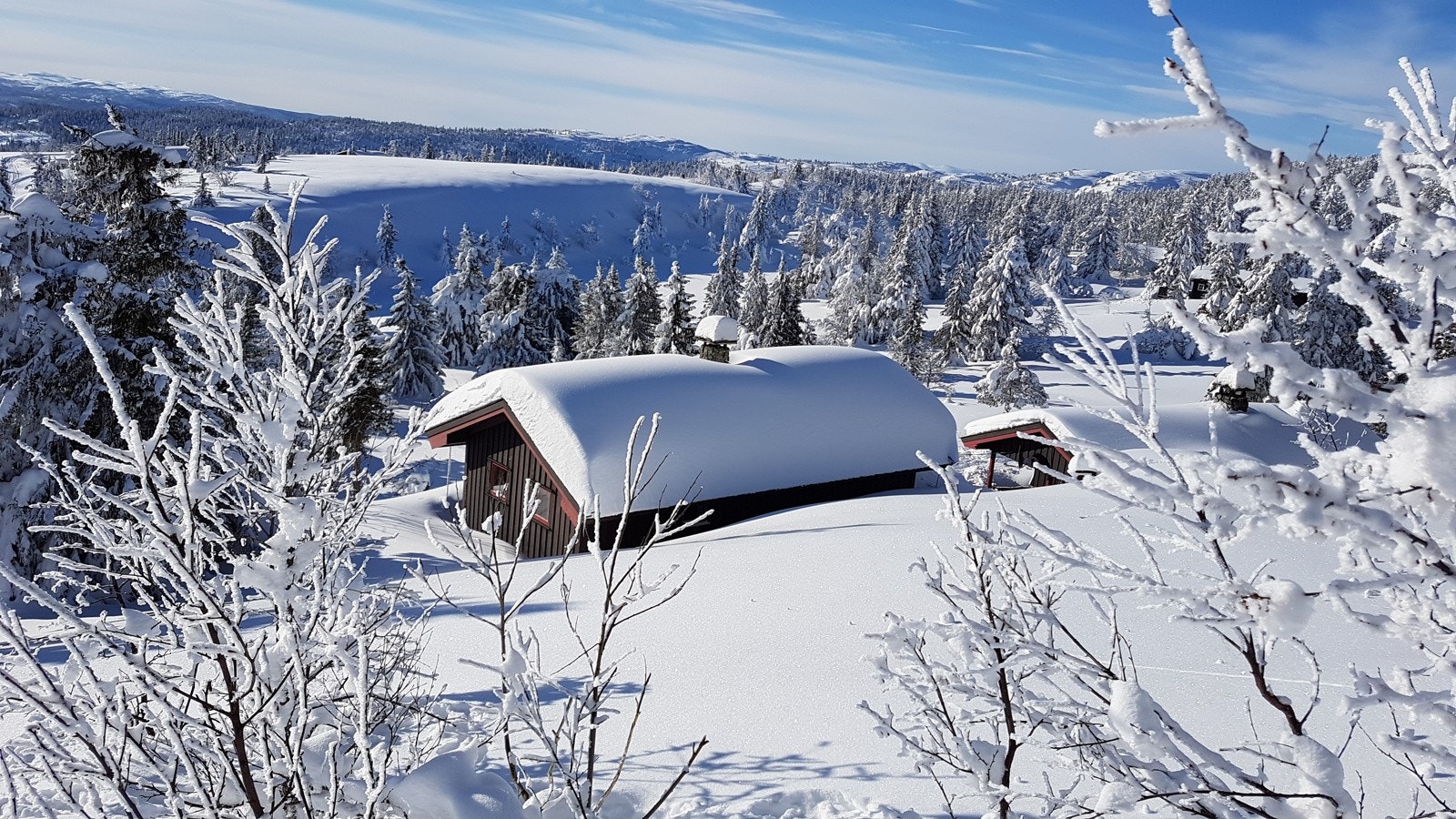 Hytta speiler seg i solen vinterstid - Bilde fra selgers arkiv Galleribilde