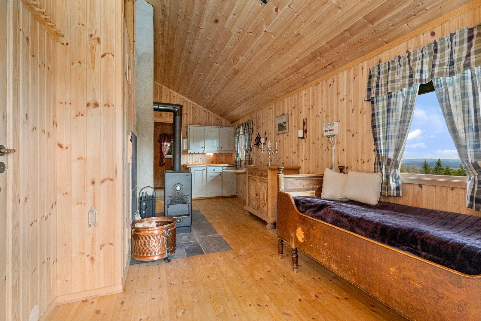 Oppholdsrom med stue og enkel kjøkkeninnredning. Vedovn som gir en rask oppvarming Galleribilde