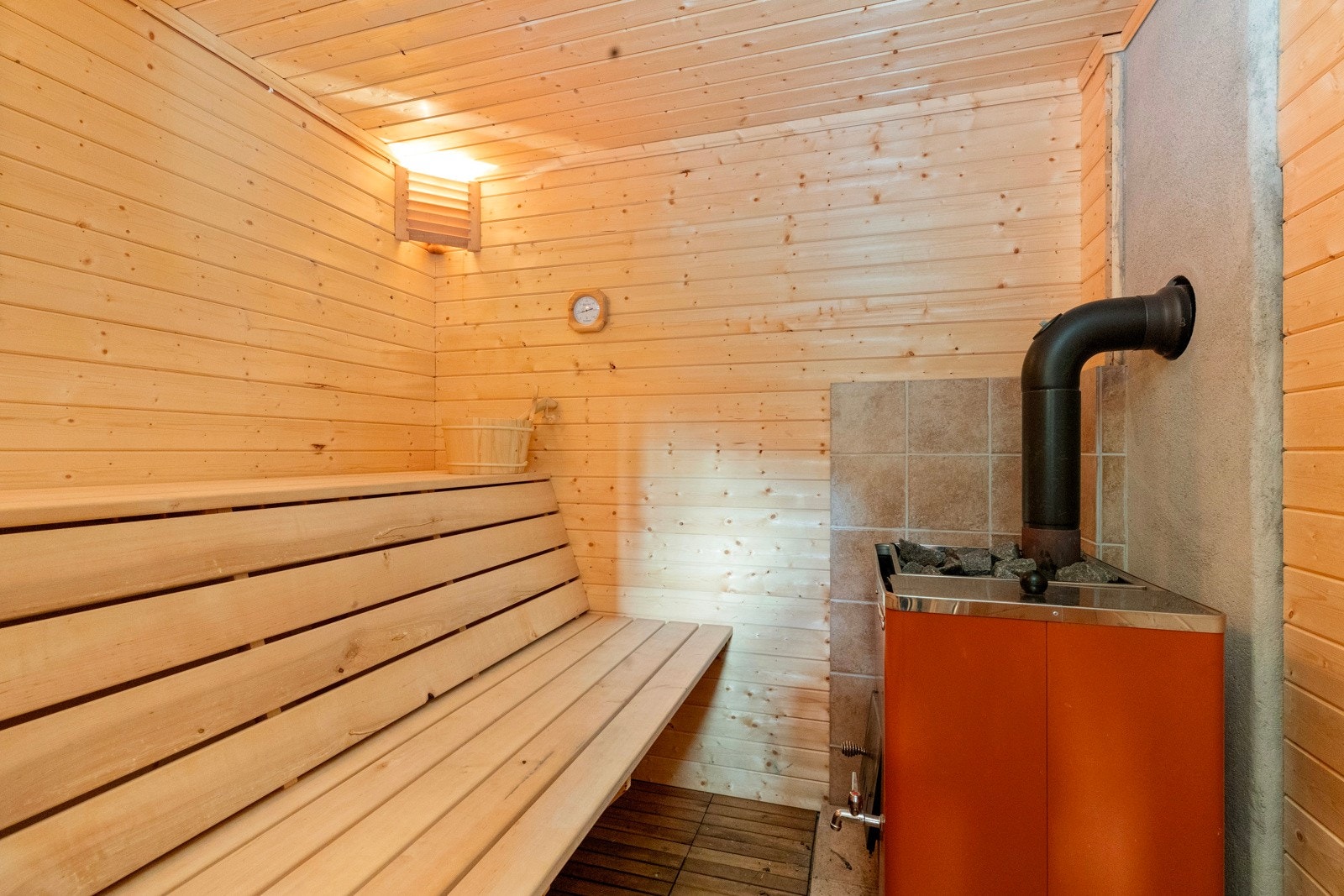 Adkomst til badstue med plassbygde sittebenker. Galleribilde