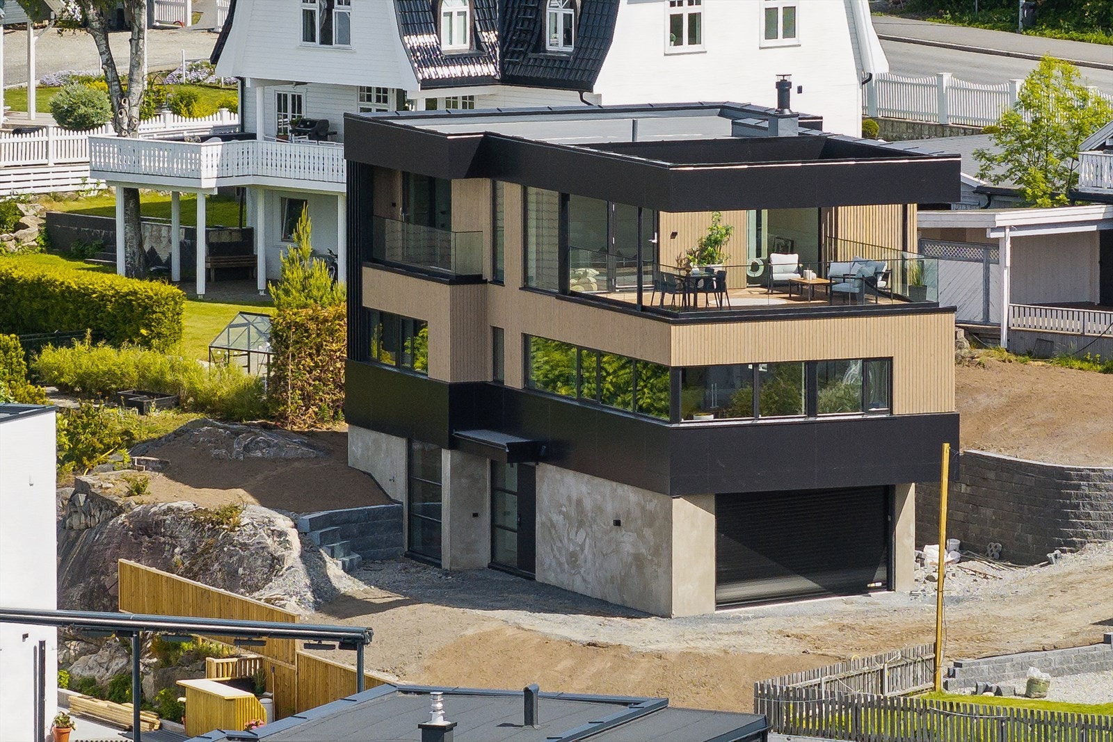 Boligen er over tre plan med bl.a. integrert dobbelgarasje og inntrukket takterrasse Galleribilde