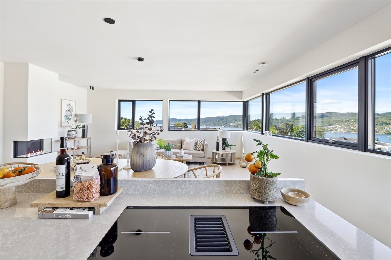 Kjøkkenøy har benkeplate i stein med nedfelt oppvaskkum i rustfritt stål, ett-greps vannkran og platetopp med integrert avtrekk. Galleribilde