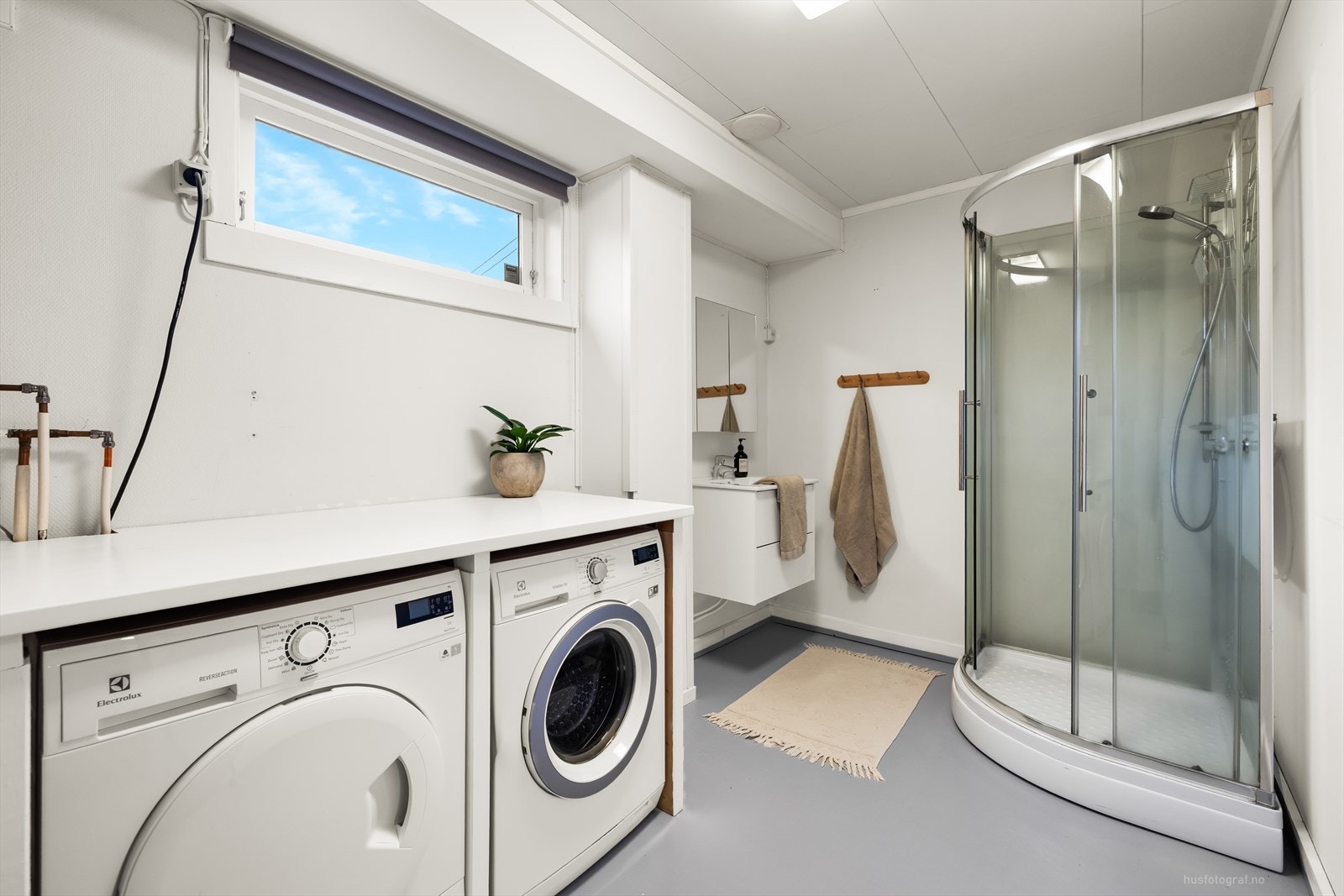Bad/vaskerom i U. etasje med baderomsinnredning, dusjkabinett, varmtvannsbereder og opplegg til vaskemaskin. Galleribilde