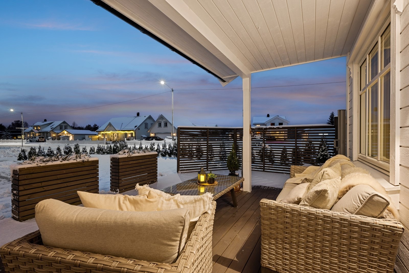 Overbygget terrasse som er diskret skjermet for innsyn med spilevegger og plantekasser i samme stil. Galleribilde