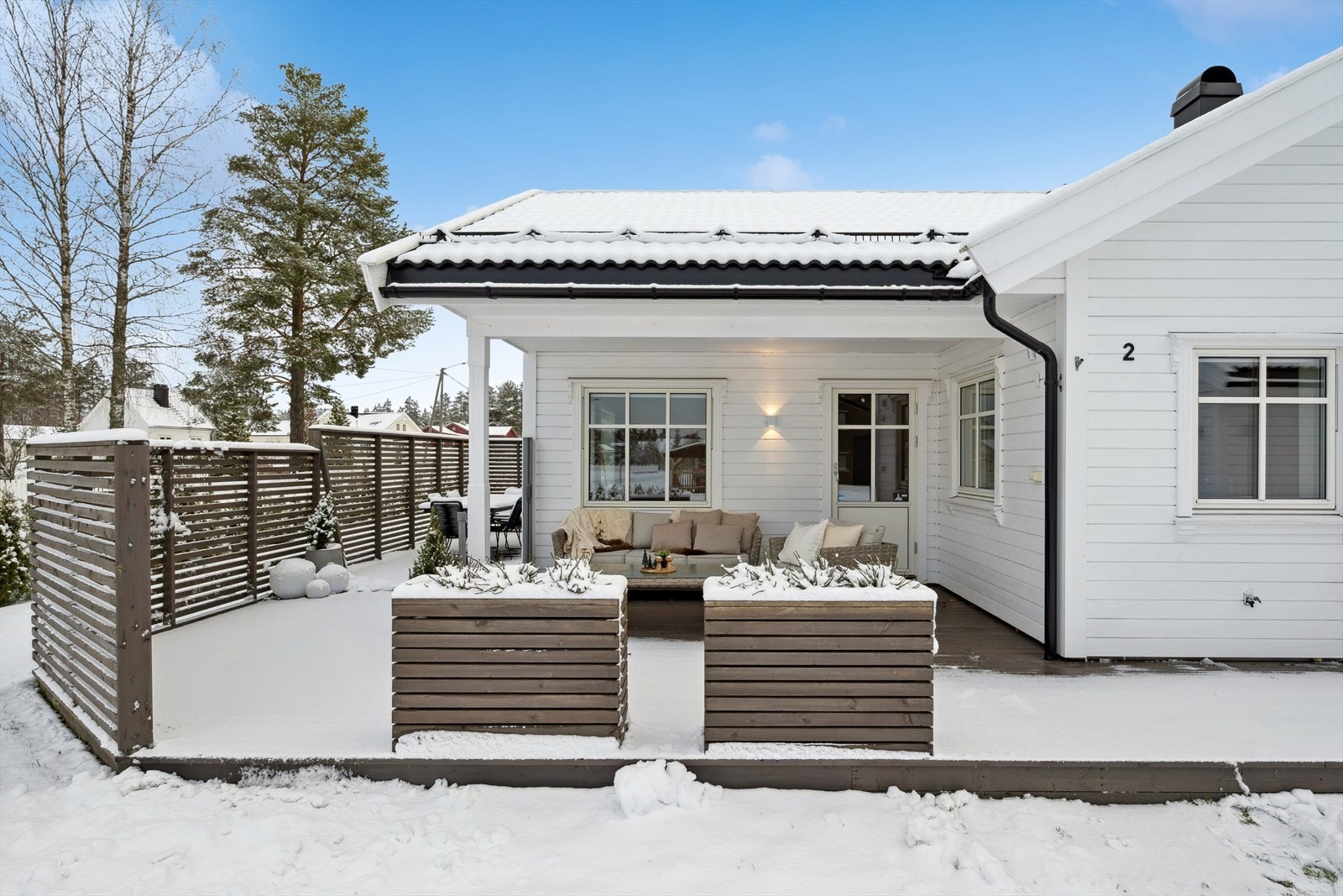 Terrassen er delvis overbygget og er godt skjermet med både spilevegg og plantekasser. Galleribilde