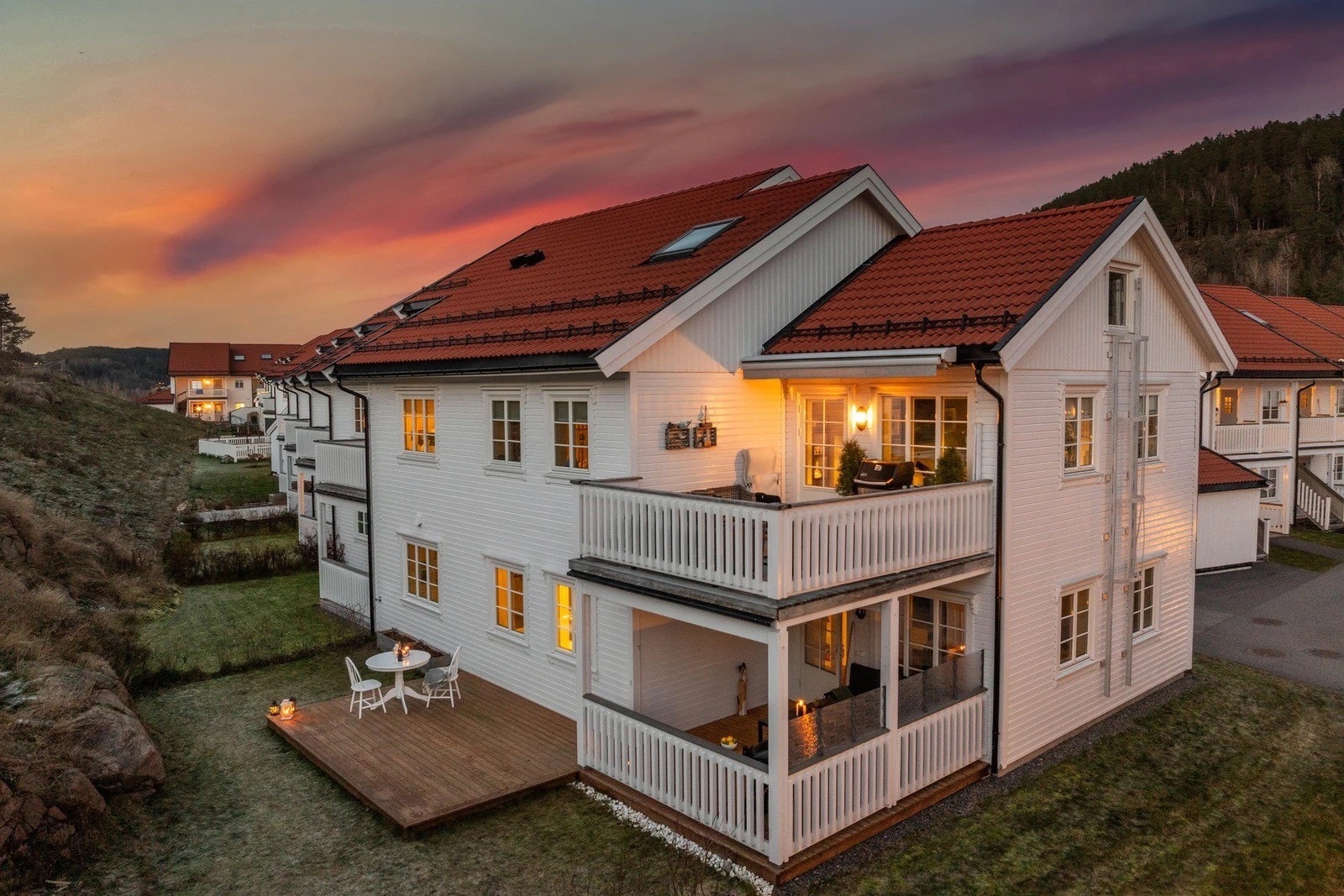 Leilighet på bakkeplan med overbygget terrasse, platting og plen. Galleribilde
