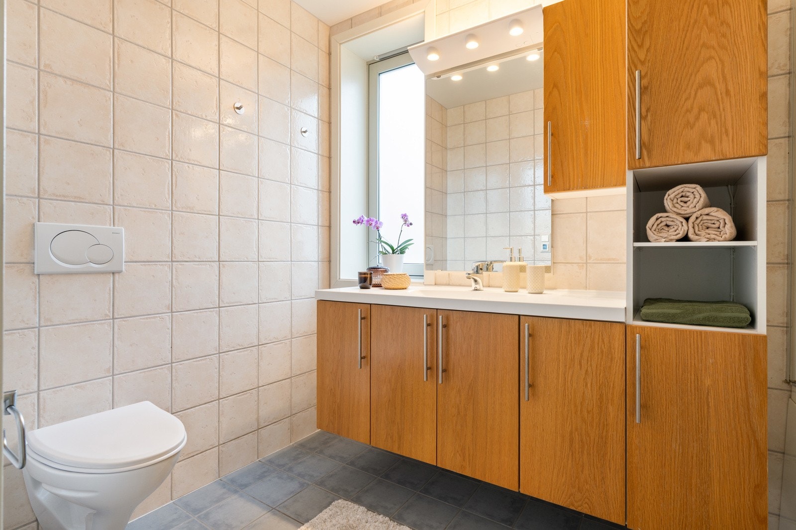 Det 4,5 kvm store badet er flislagt med behagelig gulvvarme. Galleribilde