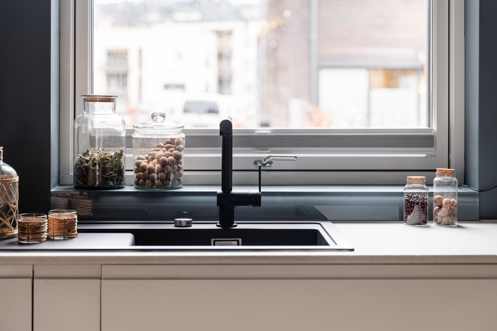 Benkeplaten er i slitesterkt komposittstein og er enkelt å rengjøre, samt gir gode arbeidsflater. Det er nedsenket, sort oppvaskkum med ett-greps armatur, og praktiske vegghengte stikkontakter over benkeplaten. Galleribilde