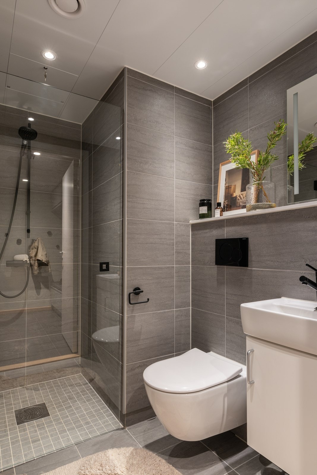 Delikat bad i 1. etasje med praktisk adkomst fra entré. Badet er utført med fliser på gulv og vegger i tidløse fargetoner. Badet er oppgradert med sorte detaljer. Galleribilde