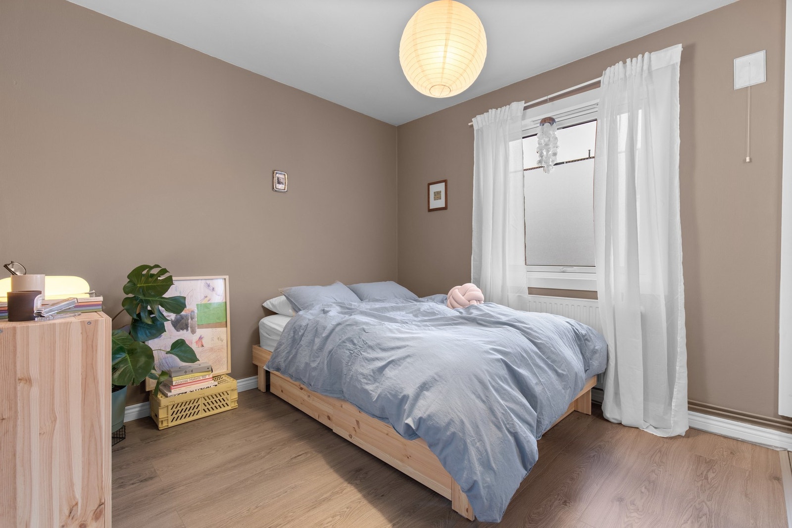 Lyst soverom med plass til dobbeltseng, rolige fargetoner og vindu som slipper inn godt med dagslys Galleribilde