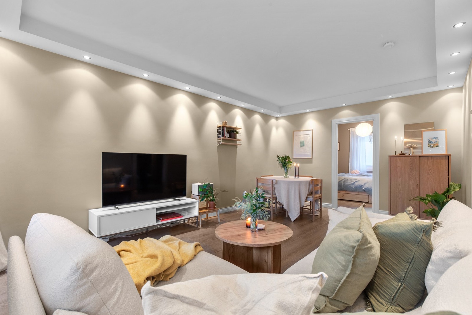 Stilren og gjennomgående stue med god plass til både sofagruppe og spisebord, dempet belysning i himling og en lun stemning som inviterer til hyggelige kvelder. Galleribilde