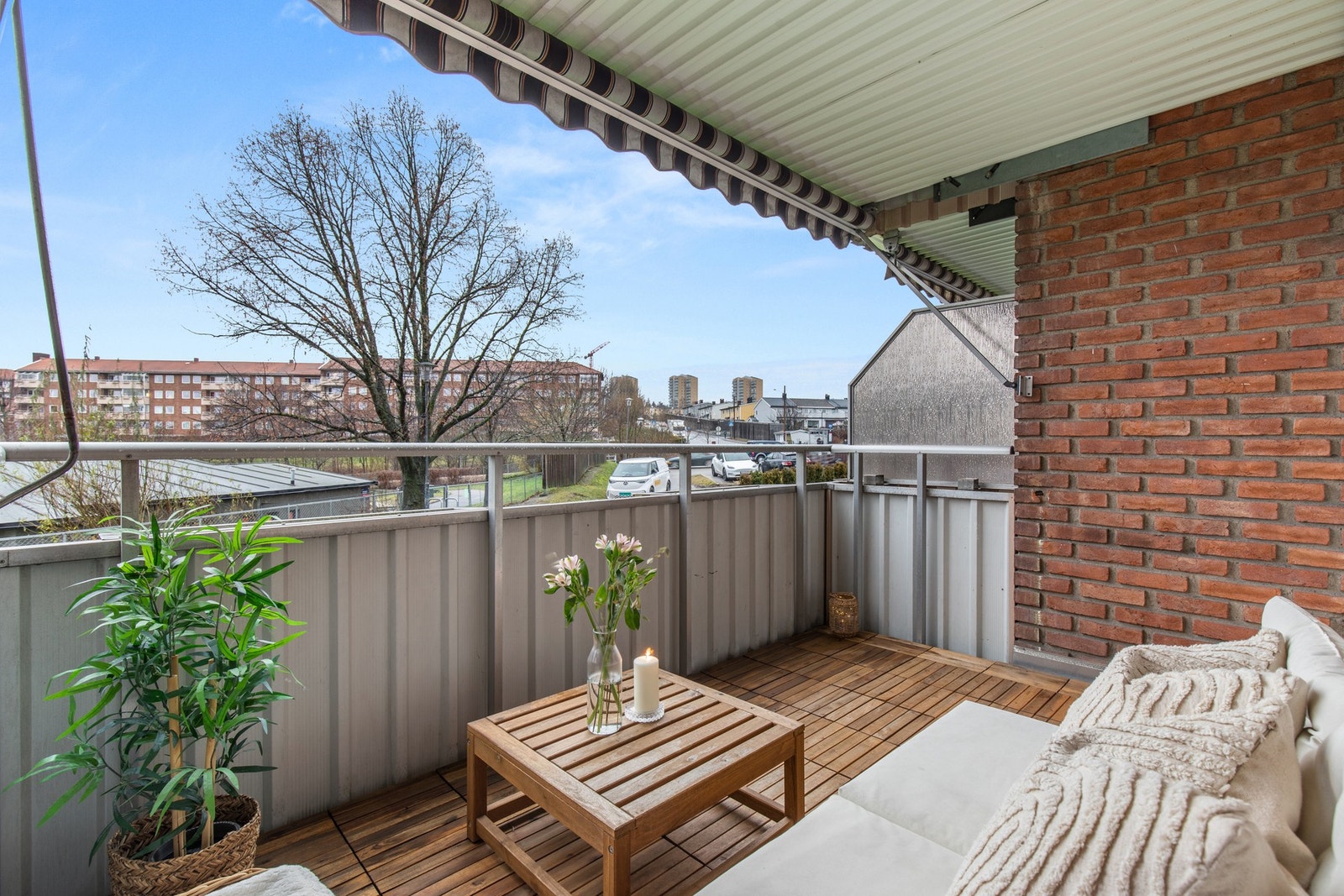 Romslig balkong med tredekke, markise og hyggelig utsyn mot grøntområder og nærområdet - ideell for rolige morgenstunder og avslapning. Galleribilde