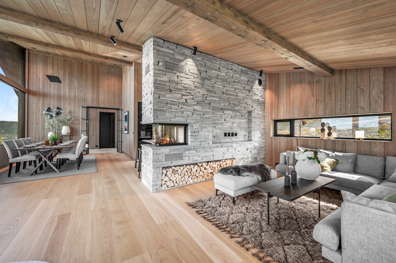 Peisen fungerer som et naturlig midtpunkt og deler stuen på en harmonisk måte Galleribilde