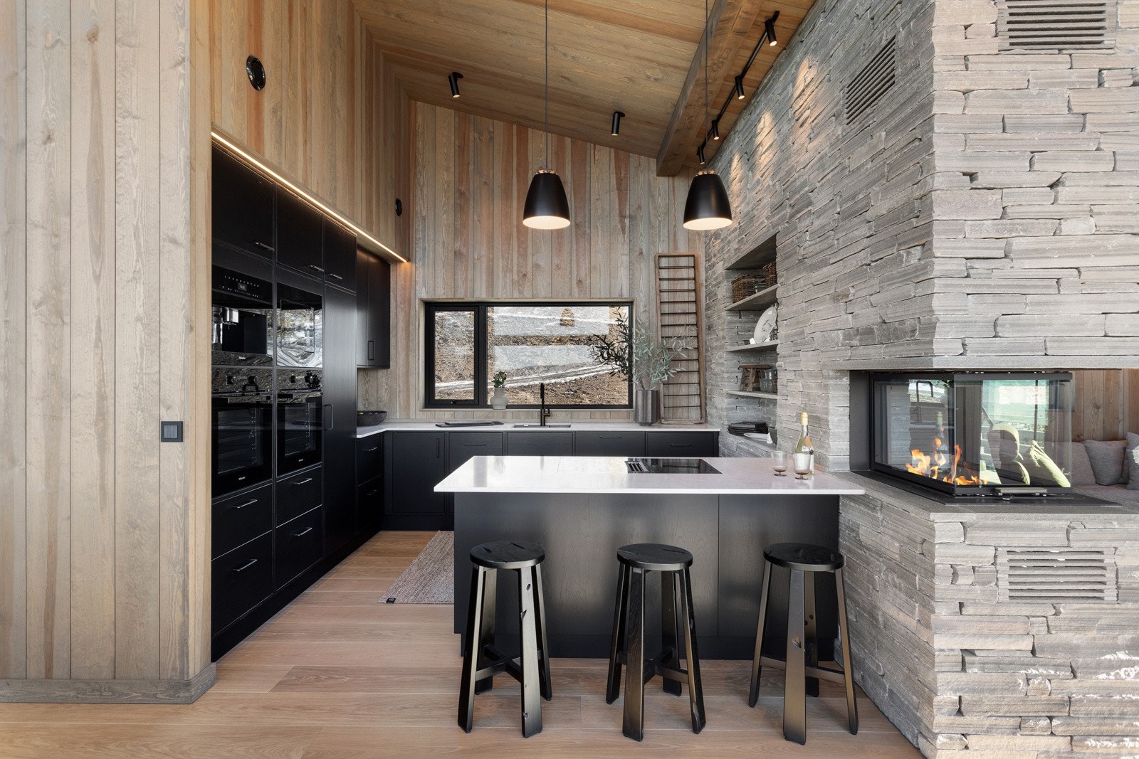 Lekker kjøkkenløsning i lakkert eik i overflaten, stein i benkeplater og integrert dobbel stekeovn, micro og kaffemaskin Galleribilde