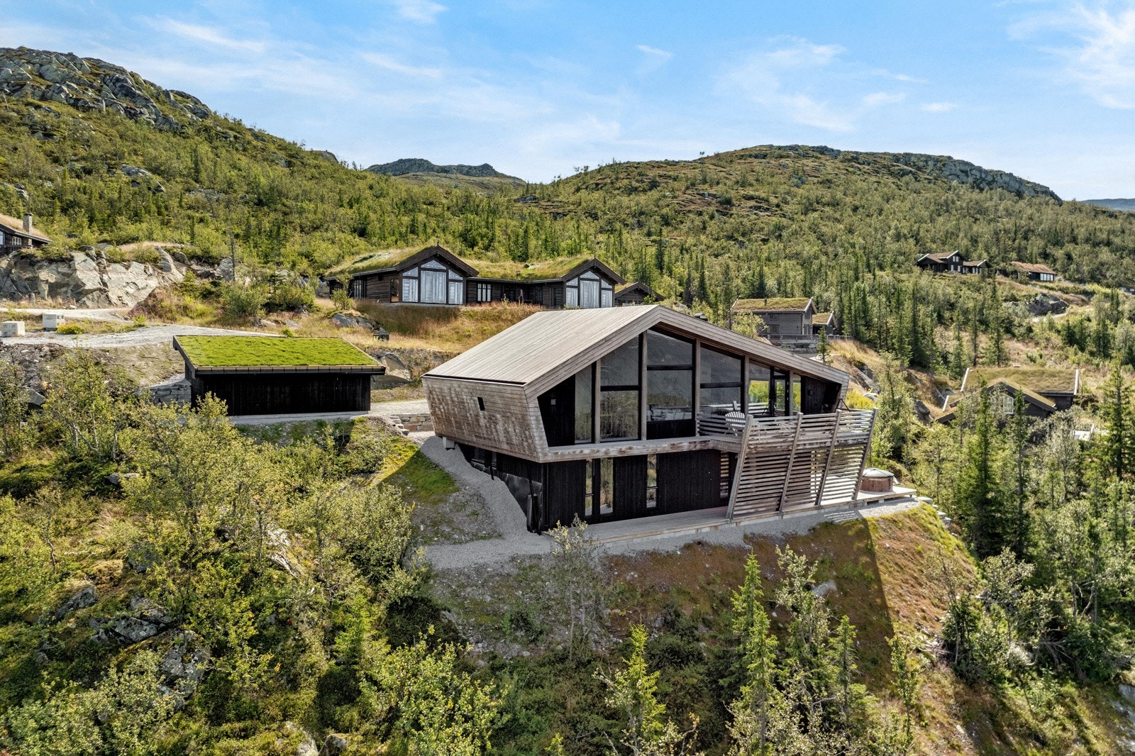 Hytta smelter naturlig inn i landskapet med moderne uttrykk Galleribilde